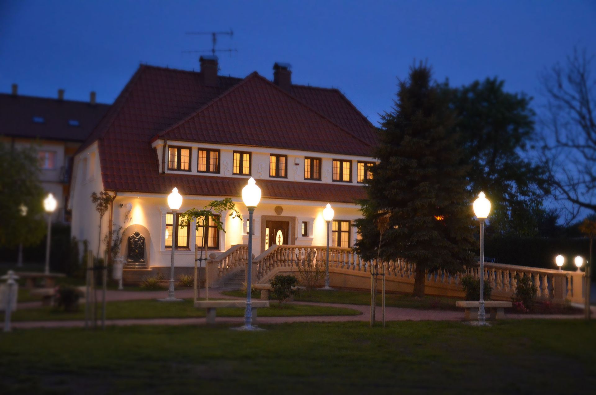Willa u Babci Maliny w Sarbinowie o zmierzchu — oświetlona fasada, balustrada i park